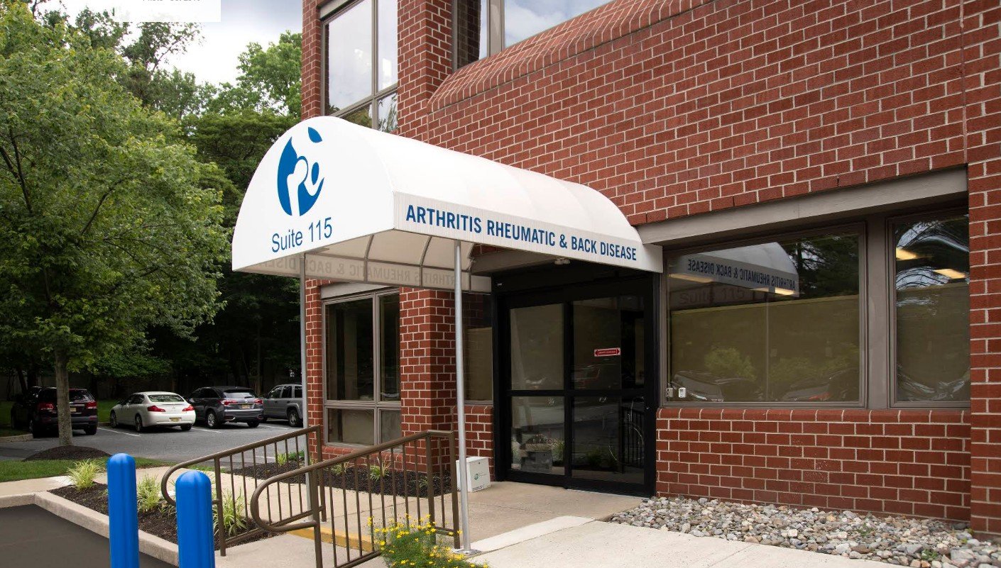 Entrance of a medical office with a sign for 'Suite 115, Arthritis Rheumatic & Back Disease.'