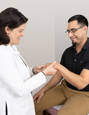 Osteoarthritis doctor talking to patient and performing a bone test in a New Jersey office